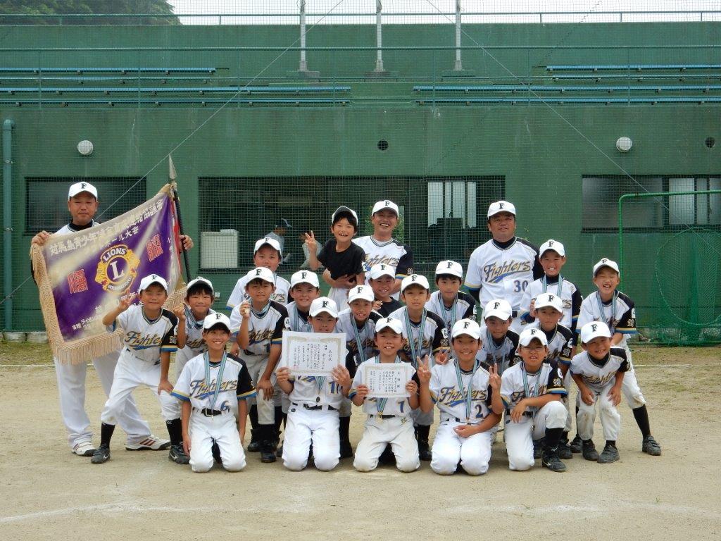 優勝旗と賞状を持ち正面を向く優勝チーム(船小ファイターズ)メンバーの写真