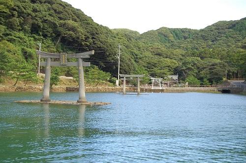 緑豊かな山を背景に石で造られた2基の鳥居がどっしりと海の中に建つ和多都美神社の写真