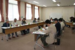 テーブルを囲んで討議する第7回検討委員会の様子の写真
