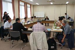 テーブルを囲んで討議する検討委員会の様子の写真