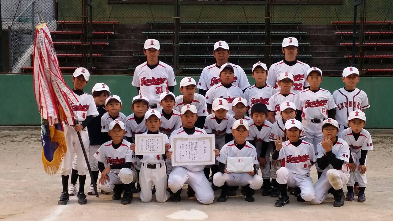 優勝旗と賞状を持ち正面を向く優勝チーム（厳原少年クラブ）メンバーの写真