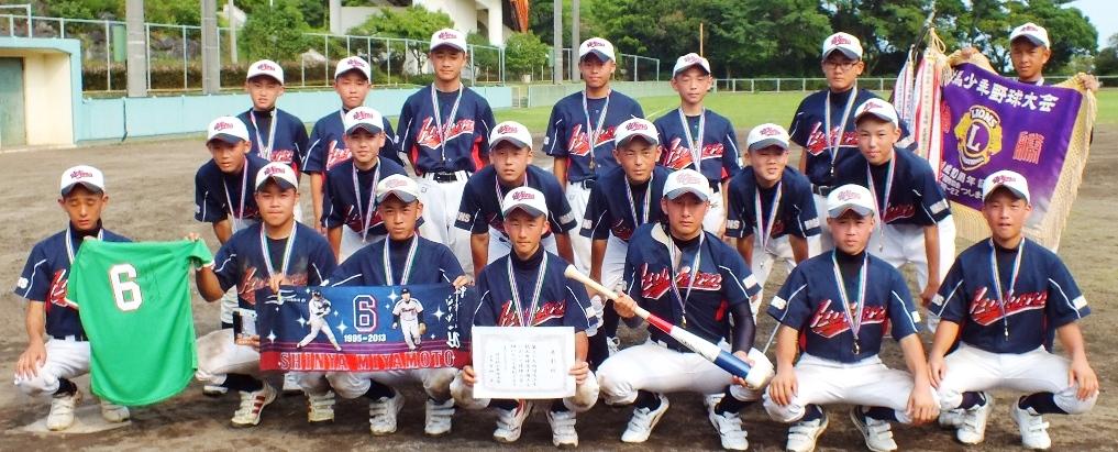 賞状とトロフィーや野球のグッズを手に正面を向く優勝チーム（厳原ウインズ）メンバーの写真