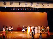 日本歌謡大会の舞台に並ぶ参加者たちの写真