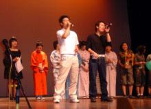 日本歌謡大会でマイクを片手に歌う二人組の男性の写真